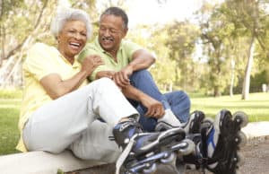 Senior Couple Putting On In Line Skates In Park